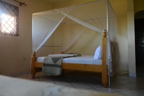 a bed with a canopy in a room at Lakeshore Bed and Breakfast in Entebbe