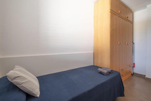 a bedroom with a blue bed and a wooden cabinet at La Galera in Torredembarra