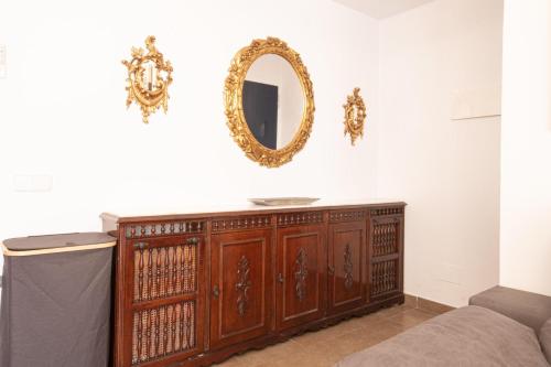 a mirror on a wall above a wooden cabinet at La Galera in Torredembarra