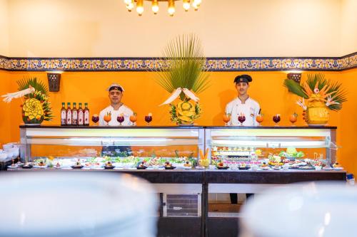 two chefs standing behind a counter with food at Faraana Heights Aqua Park in Sharm El Sheikh