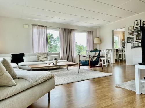 a living room with a couch and a table at Summerhouse in south of Norway with privat boat house. in Arendal