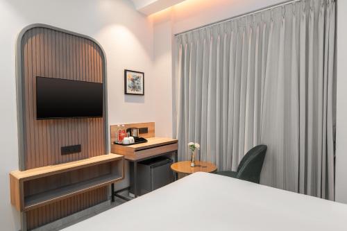 ムンバイにあるAjanta Continental-Mumbai Airportのベッドと机があるホテルの部屋