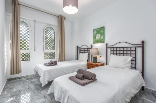 マルベーリャにある200m from the beach Apartment San Pedro Marbellaのベッドルームにタオル付きのベッド2台が備わります。