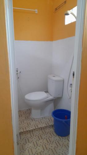 a bathroom with a toilet and a blue bucket at Kokas Room in Jakarta