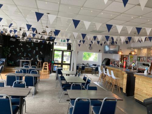 a restaurant with tables and chairs and a bar at Brixham Holiday Park Gold 2 Bedroom Holiday Home in Brixham