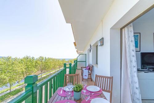 un balcón con una mesa con copas de vino. en Apart-rent Apartment Port Ducal 0148, en Empuriabrava