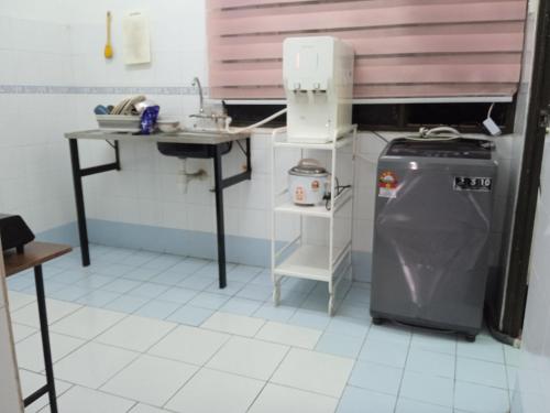 eine kleine Küche mit Spüle und Kühlschrank in der Unterkunft Homestay Idaman Penang in Permatang Pauh