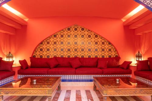 a living room with a red couch and two tables at Faraana Heights Aqua Park in Sharm El Sheikh