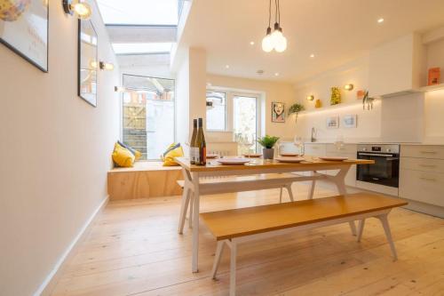a kitchen with a wooden table and a dining room at Stunning Broadstairs 5 bed Family Hse, Parking, Garden in Kent