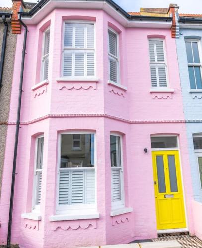 a pink house with a yellow door and windows at Stunning Broadstairs 5 bed Family Hse, Parking, Garden in Kent