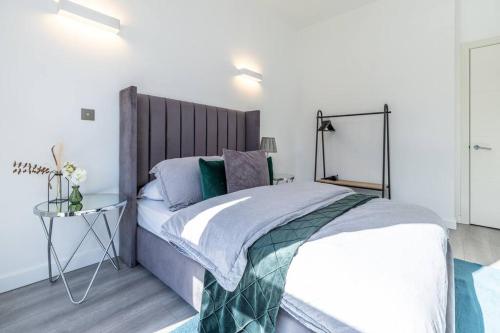 a bedroom with a large bed with a wooden headboard at Elegant apartment/2 in Buckinghamshire