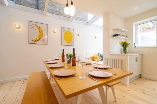 a dining room with a wooden table with wine glasses at Stunning Broadstairs 5 bed Family Hse, Parking, Garden in Kent