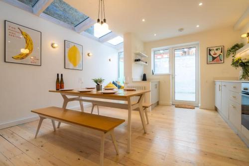 a kitchen with a wooden table and a dining room at Stunning Broadstairs 5 bed Family Hse, Parking, Garden in Kent