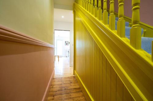 a hallway with yellow stairs in a room at Stunning Broadstairs 5 bed Family Hse, Parking, Garden in Kent