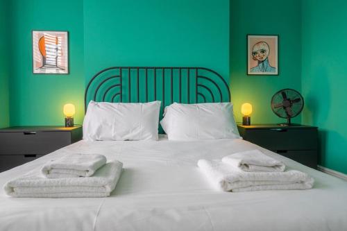 a bedroom with a white bed with towels on it at Stunning Broadstairs 5 bed Family Hse, Parking, Garden in Kent