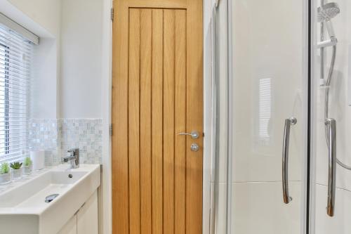 uma casa de banho com uma porta de chuveiro em madeira ao lado de um lavatório em 1BR Gem in Great Location em Sheffield