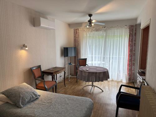 een kamer met een bed, een tafel en een raam bij Résidence Les Milandes in Cazaubon