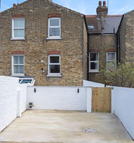 a brick house with a white fence and a driveway at Stunning Broadstairs 5 bed Family Hse, Parking, Garden in Kent