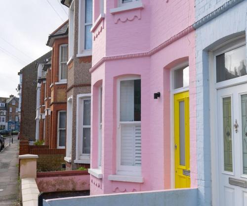 a pink house with a yellow door on a street at Stunning Broadstairs 5 bed Family Hse, Parking, Garden in Kent