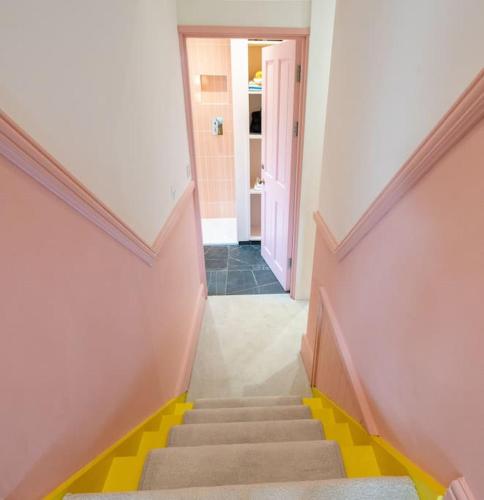 a stairway with yellow steps in a hallway at Stunning Broadstairs 5 bed Family Hse, Parking, Garden in Kent