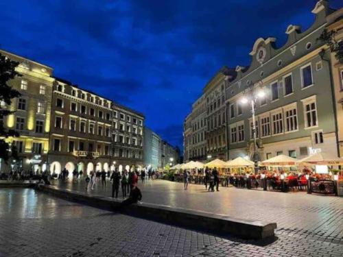 a city street at night with people and buildings at Heart of Old Town / Floriańska 19 in Krakow