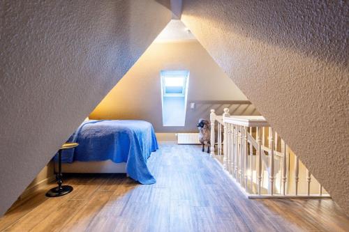 Zimmer im Dachgeschoss mit einem Bett und einer Treppe in der Unterkunft Heefwai 2 W5 in Morsum
