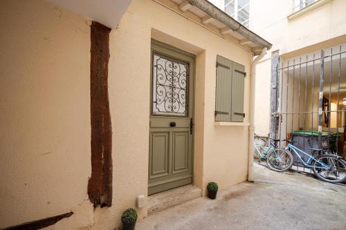 une porte d'un immeuble avec deux vélos garés à côté de celui-ci dans l'établissement Superb tiny house in heart of Paris 1st!, à Paris