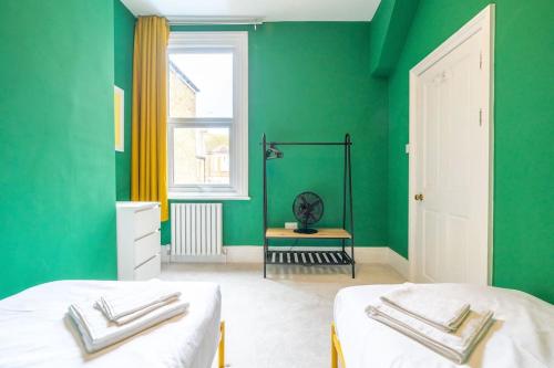a green bedroom with two beds and a window at Stunning Broadstairs 5 bed Family Hse, Parking, Garden in Kent