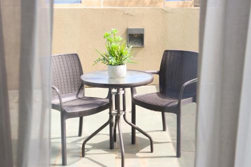 a table with chairs and a potted plant on a patio at Eurohotel Barcelona Granvia Fira in Hospitalet de Llobregat