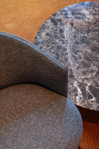 a close up of a chair next to a marble table at Casa Faraona Luxury Residences in Madrid