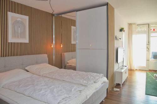 Un dormitorio con una cama blanca en una habitación. en Kaiserhof App 213 inkl WLAN, en Grömitz