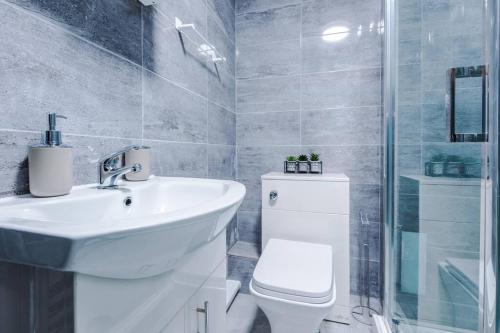 een badkamer met een wastafel, een toilet en een douche bij LFC Themed Apartment Anfield in Liverpool