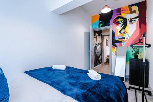 een kamer met een bed met een schilderij aan de muur bij LFC Themed Apartment Anfield in Liverpool