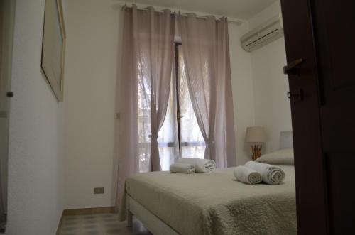a bedroom with two pillows on a bed with a window at Appartamenti Fronte Mare Fertilia FAHO-GAV01-GAV02 in Fertilia