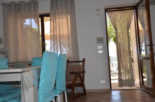 a kitchen with a table and a door to a yard at Appartamenti Fronte Mare Fertilia FAHO-GAV01-GAV02 in Fertilia