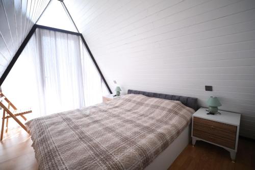 1 dormitorio con cama y ventana grande en Mirvari Aframe, en Quba