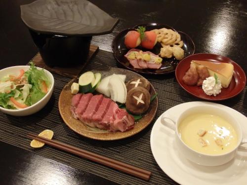 a table with plates of food and a bowl of soup at Forest Villa YUMESUZU the Closest Accommodation to the Metasequoia Tree-lined Avenue in Takashima