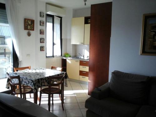 sala de estar con mesa y sillas y cocina en Appartamento Fiore, en Alghero
