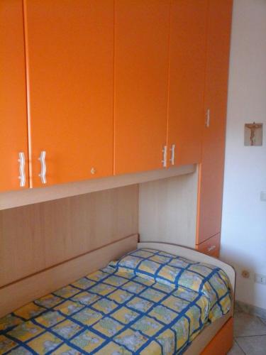 a small bedroom with orange cabinets and a bed at Appartamento Fiore in Alghero
