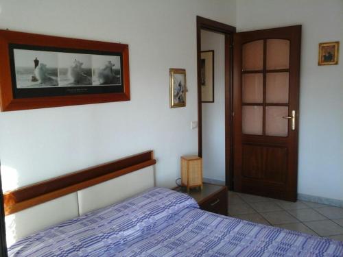 a bedroom with a bed and a tv on the wall at Appartamento Fiore in Alghero