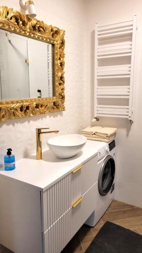 a bathroom with a sink and a washing machine at APARTAMENT JARACZA 28/17 in Słupsk