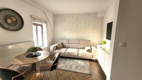 a living room with a couch and a table at APARTAMENT JARACZA 28/17 in Słupsk