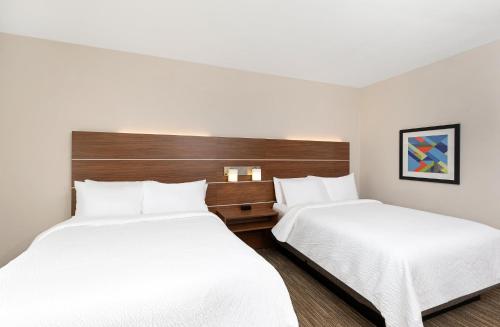 two beds in a hotel room with white sheets at Holiday Inn Express Hotel & Suites Birmingham - Inverness 280 by IHG in Birmingham