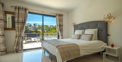 une chambre avec un lit et une grande fenêtre dans l'établissement Villa Les Arbousiers - Piscine Chauffée Sécurisée - 210m2 - 4 Suites, à Porto-Vecchio