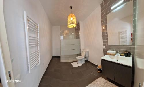 La salle de bains est pourvue d'un lavabo, de toilettes et d'un lustre. dans l'établissement Appartement cosy proche du stade et de la plage, à Marseille