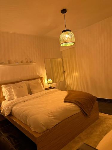 - une chambre avec un grand lit blanc et une lumière dans l'établissement Appartement cosy proche du stade et de la plage, à Marseille