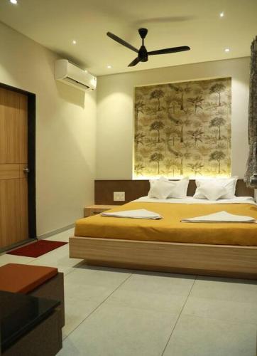 a bedroom with a bed with a ceiling fan at 'Sumadhu Homes 301 ' in Kolhapur