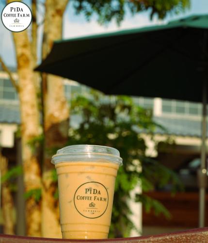 a cup of coffee sitting on a table at PIDA COFFEE FARM LODGE in Phumĭ Pu Pal