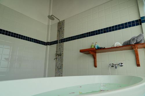 a bathroom with a shower and a bath tub at PIDA COFFEE FARM LODGE in Phumĭ Pu Pal