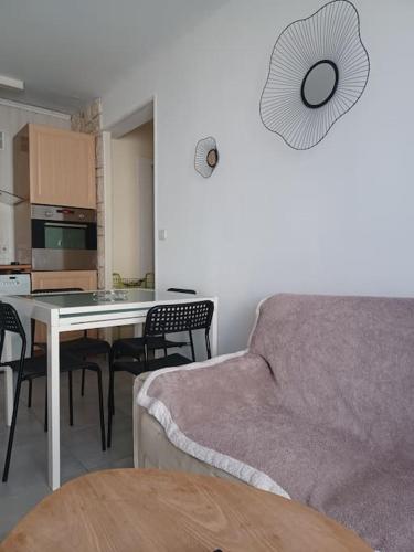 un salon avec un canapé et une table avec des chaises dans l'établissement appartement 2 chambre, climatisation, plage à 50m, à Palavas-les-Flots